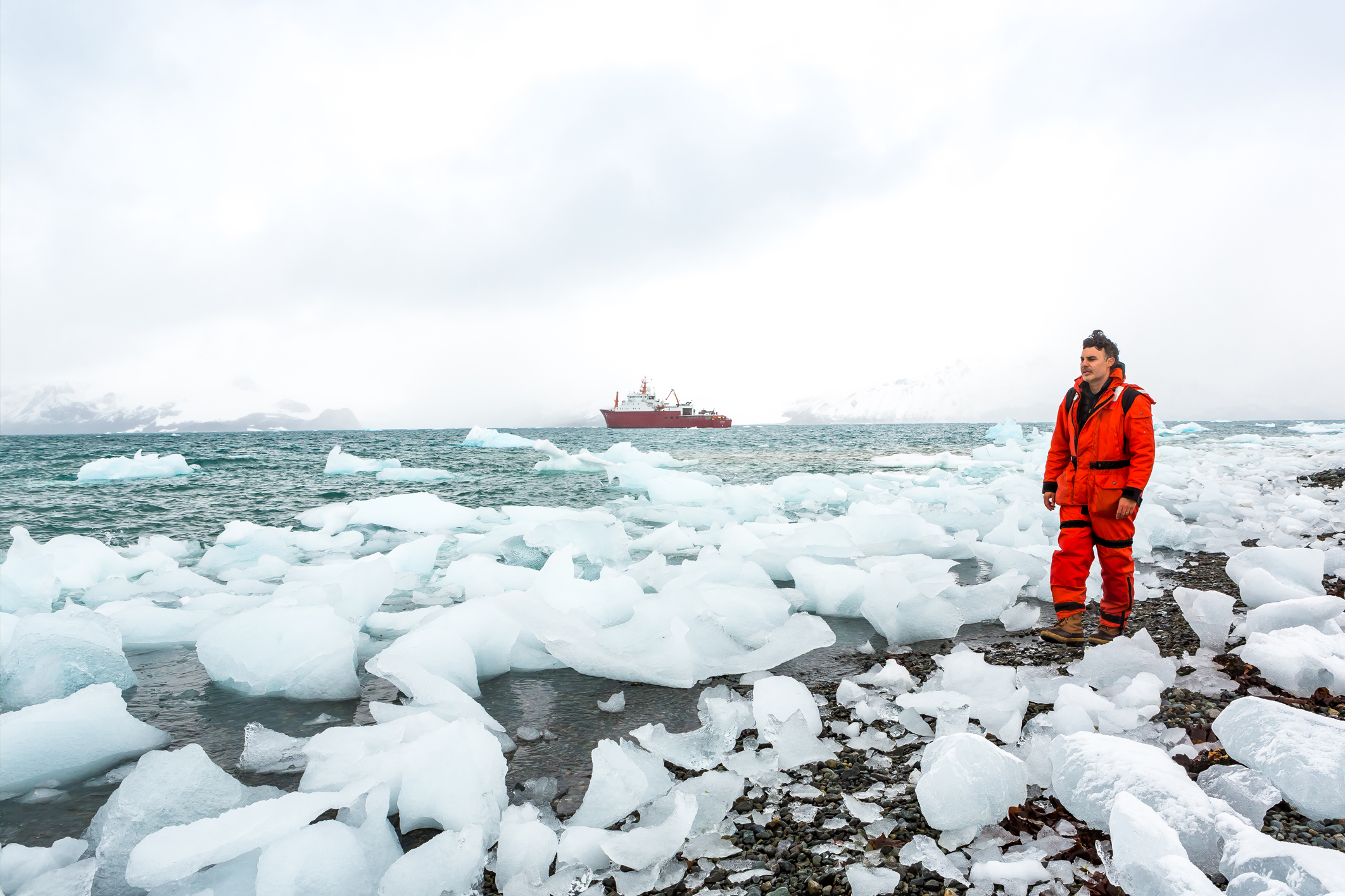 Man walking along icy beach